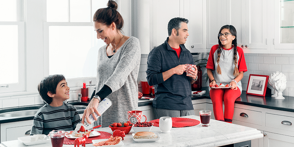 Happy family in kitchen cooks and discovers ways to save on heating costs.