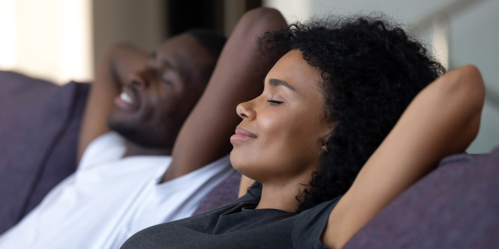 final-image Young couple relax on couch under the comfort of zoning systems.