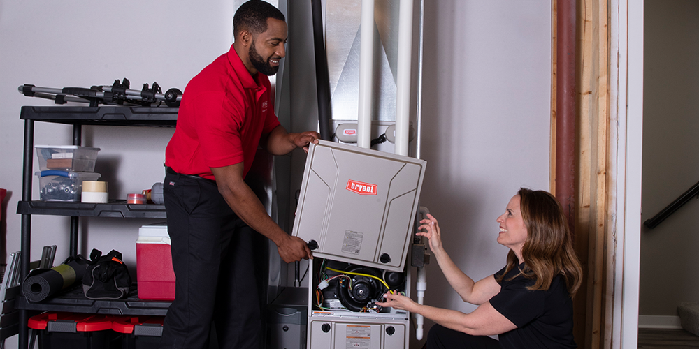 Replace Your Furnace Two technicians replace your furnace in homeowner's basement.